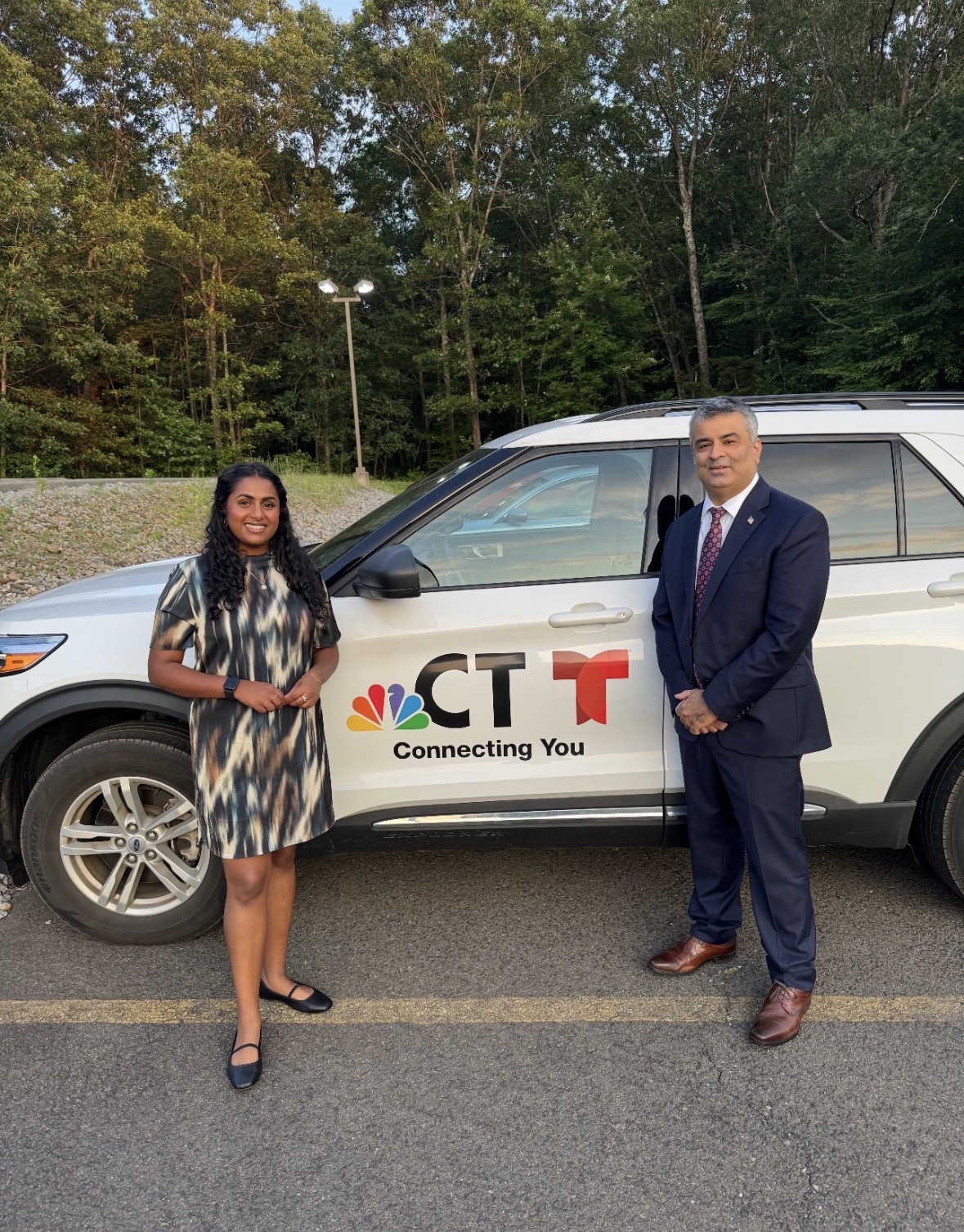 Rajeev Pahuja with a television reporter beside an NBC Connecticut and Telemundo news vehicle